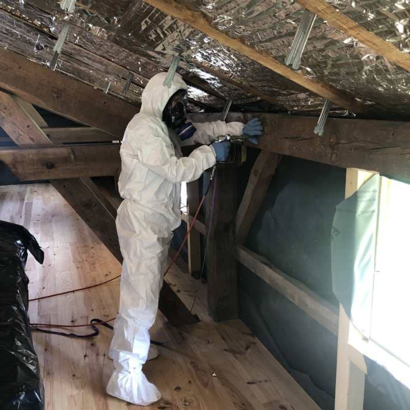 Technicien BDX Termites Audenge en combinaison de protection traitant une poutre de charpente